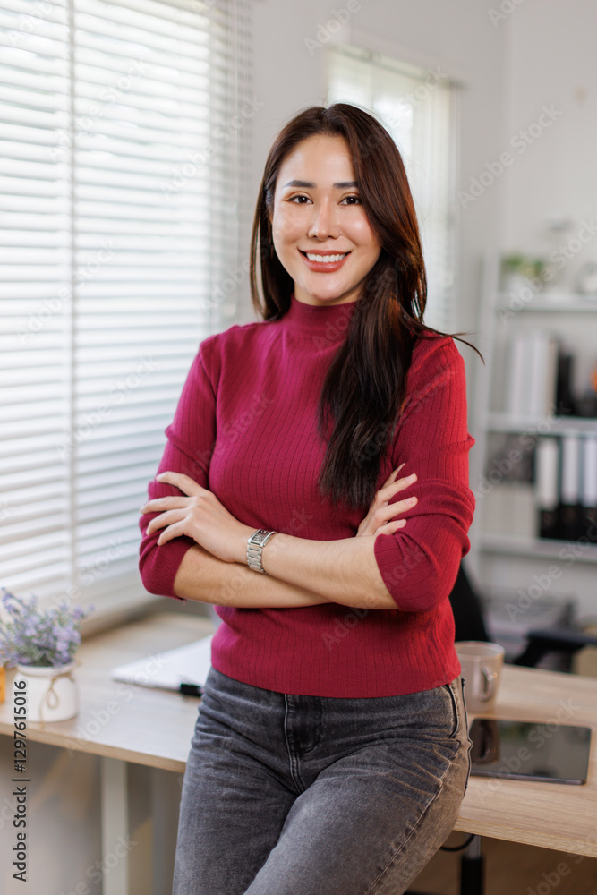 Portrait of a confident smiling Asian woman dressed in red, standing with arms folded and looking at the camera at home office
Portrait of a confident smiling Asian woman dressed in red, standing with arms folded and looking at the camera at home office