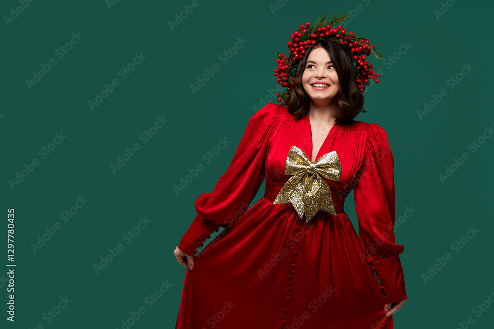 Smiling woman in red dress with gold bow posing playfully