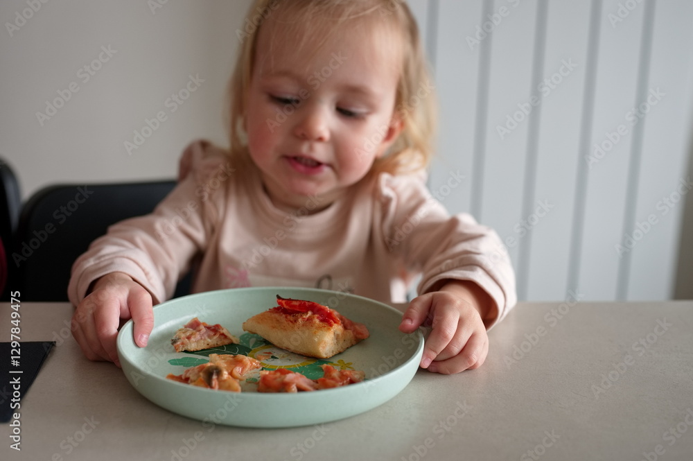 Little girl sitting at the table and eating pizza Little girl sitting at the table and eating pizza