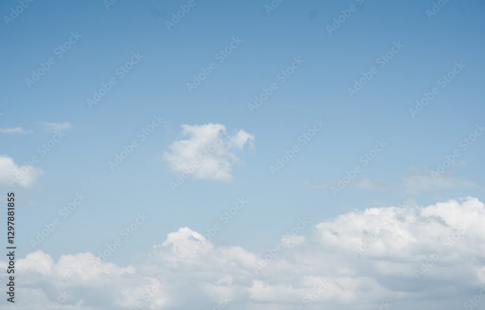 A stunning image showcasing a clear blue sky with soft, scattered white clouds A stunning image showcasing a clear blue sky with soft, scattered white clouds
