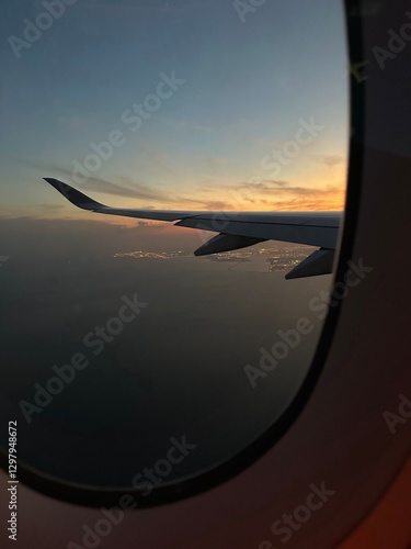 Airplane window view of sunset overlooking Doha, Qatar