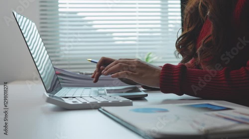 Businesswoman working with calculator and laptop in office