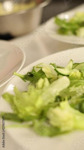 there are only hands in the frame, which are preparing a salad with pears and nuts, carefully laying out the ingredients.