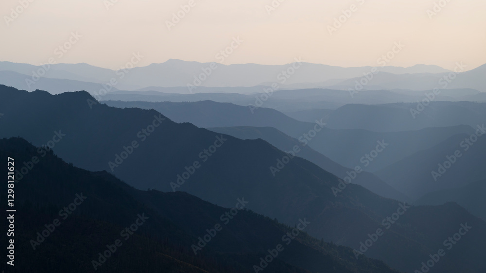 View of the receding peaks of the Sierra Nevada mountain range, California, USA. The distant peaks are hazy in the bright sunlight View of the receding peaks of the Sierra Nevada mountain range, California, USA. The distant peaks are hazy in the bright sunlight