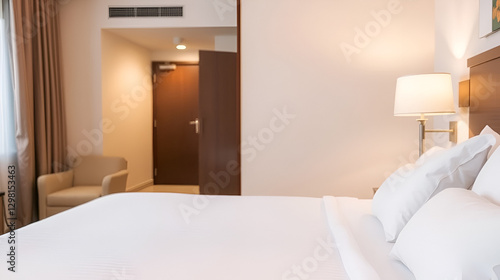 A hotel room features a well-made bed with crisp linens and soft lighting, evoking feelings of comfort, cleanliness, and welcoming hospitality in a serene setting.