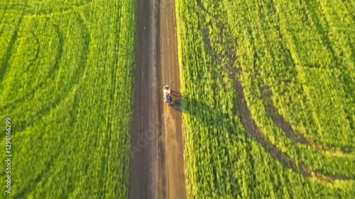 A motorcycle rides among green fields