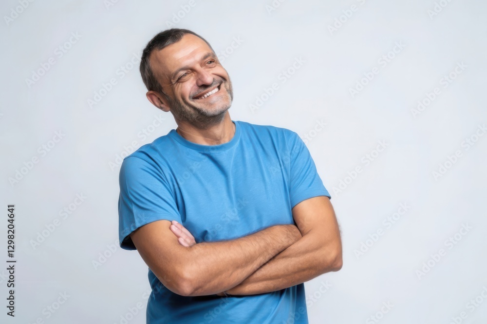 Smiling Man in Blue T-Shirt with Joyful Expression Against Gray Background Smiling Man in Blue T-Shirt with Joyful Expression Against Gray Background