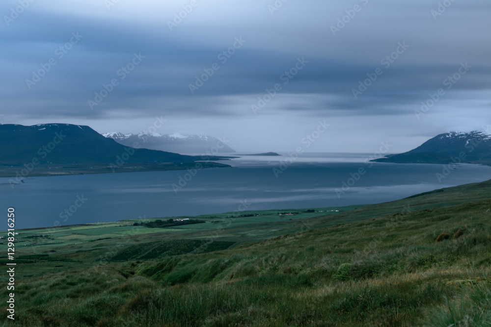 Obraz premium Scenic view of a fjord under dramatic cloudy sky