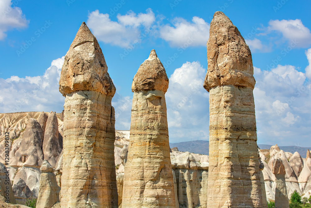 Unique rock formations rise majestically under a bright blue sky in Cappadocia.