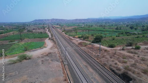 Aerial view of the saffron coloured Vande Bharat Express near Pune India. This train is between Pune and Kolhapur and also a tri-weekly train between Pune and Hubbali.