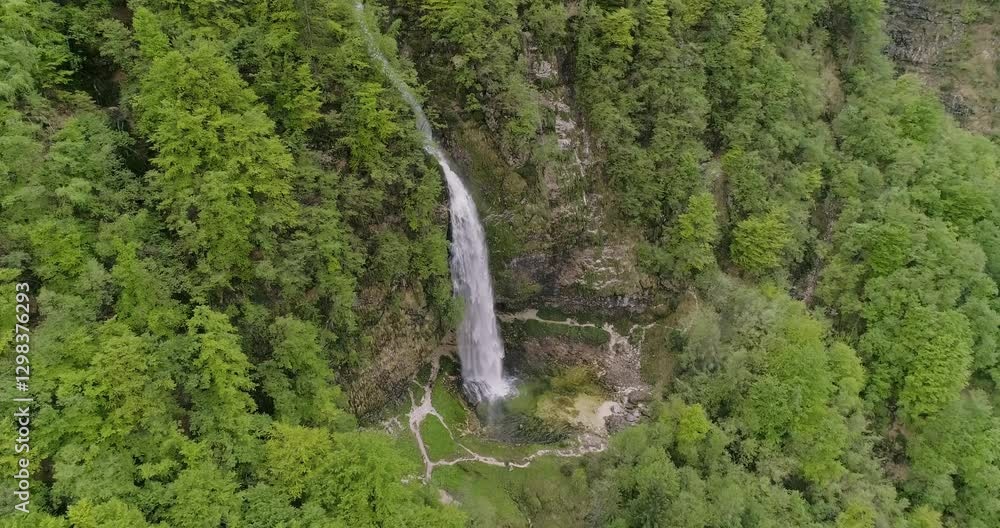 Fontanon of Goriuda, Udine. Wonderful waterfall that falls from a cliff. The force of the waterfall is a sight to behold. Hiking, trekking in the open area surrounded by woods. Summer holidays, peace. Fontanon of Goriuda, Udine. Wonderful waterfall that falls from a cliff. The force of the waterfall is a sight to behold. Hiking, trekking in the open area surrounded by woods. Summer holidays, peace.