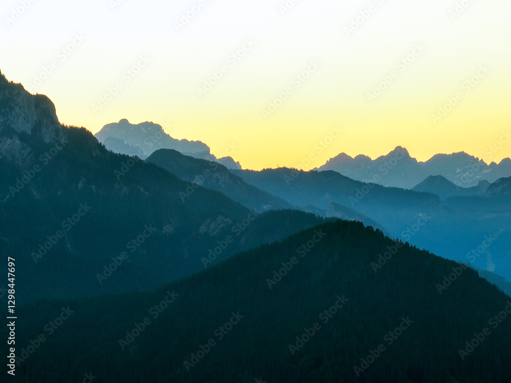 Fototapeta premium Breathtaking mountain scenery, Dolomites glowing warm sunlight. Peaks rise aerial view, casting dramatic shadows. Atmosphere makes perfect for travel, outdoor adventures, nature appreciation, getaways