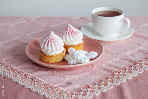 white and pink cupcakes  and cup of tea on vintage tablecloth