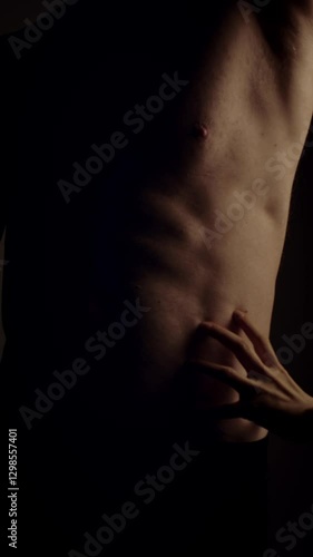 Female hands touching male's fit torso with passion. Slow motion. Vertical orientation