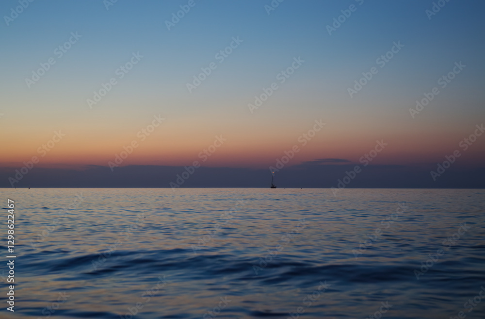Fototapeta premium big waves at sunset, beautiful high waves at the beach, view at sea, sunset at the sea in Italy, grey clouds, blue and purple colors, foaming goutweed, purple sky, pink and blue sky 