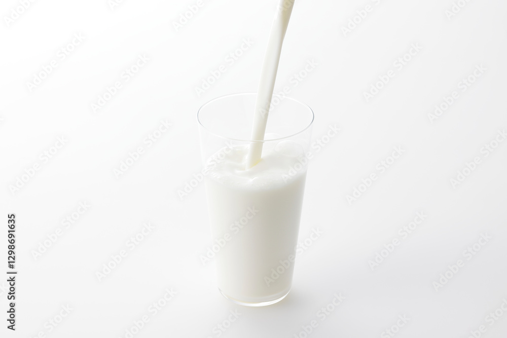 白い背景とグラスに注いだ牛乳 Milk poured into a glass with a white background 白い背景とグラスに注いだ牛乳 Milk poured into a glass with a white background