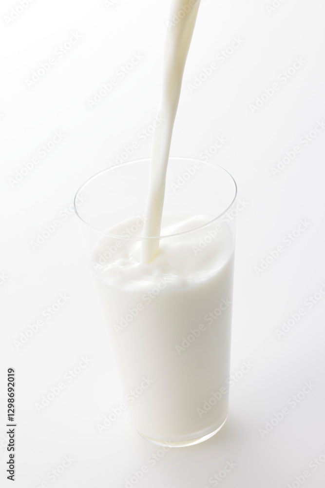 白い背景とグラスに注いだ牛乳 Milk poured into a glass with a white background 白い背景とグラスに注いだ牛乳 Milk poured into a glass with a white background