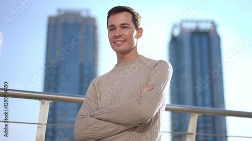 Wallpaper Mural A confident and poised man stands with arms crossed boldly against a stunning backdrop of tall skyscrapers Torontodigital.ca