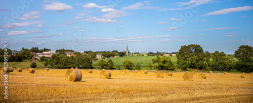 Fotografie Paysage de champ de blé et meules de foin en pleine nature en été après les moissons