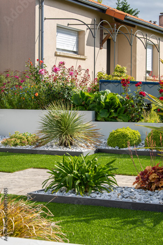 Charmant petit jardin paysagé avec ses fleurs et ses plantes vertes au printemps.