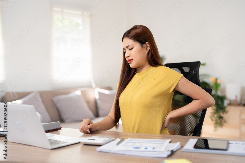 Young businesswoman feels uncomfortable sitting in office chair, woman massaging her back suffering from discomfort ache pain, incorrect posture from long sedentary work and lower backache concept Young businesswoman feels uncomfortable sitting in office chair, woman massaging her back suffering from discomfort ache pain, incorrect posture from long sedentary work and lower backache concept