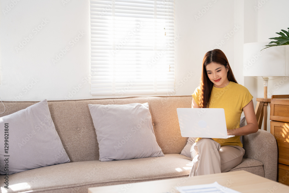 Smiling asian girl sit relax on couch using modern laptop browsing unlimited wireless internet, happy young woman freelancer work on computer typing texting from home, technology concept Smiling asian girl sit relax on couch using modern laptop browsing unlimited wireless internet, happy young woman freelancer work on computer typing texting from home, technology concept