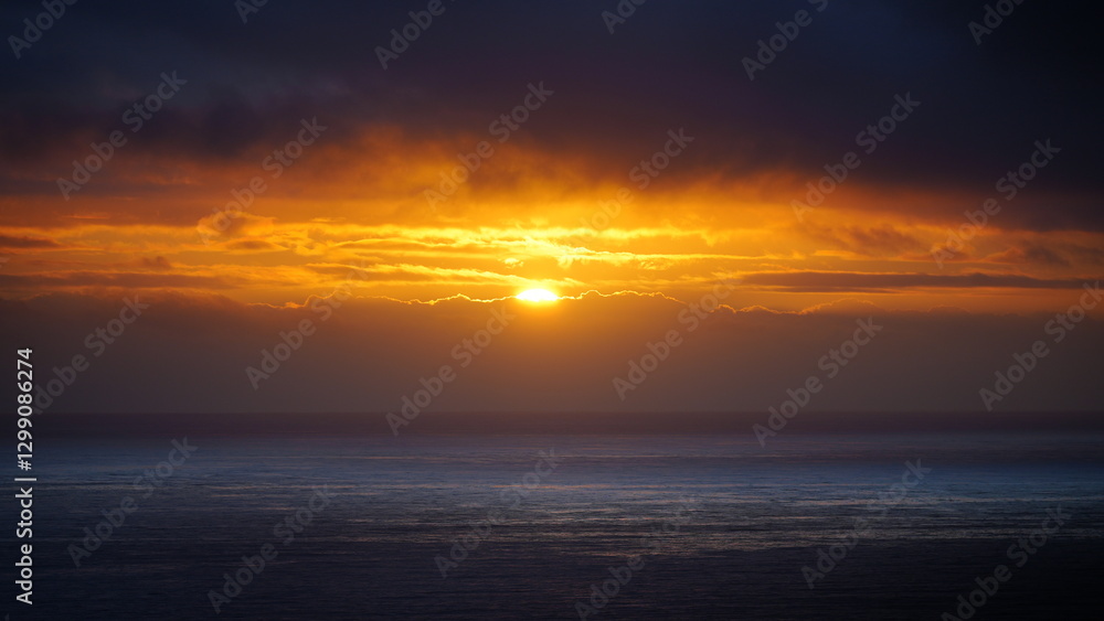 vivid orange sunset over the Atlantic Ocean, with the sky glowing in rich hues as the sun dips below the horizon vivid orange sunset over the Atlantic Ocean, with the sky glowing in rich hues as the sun dips below the horizon
