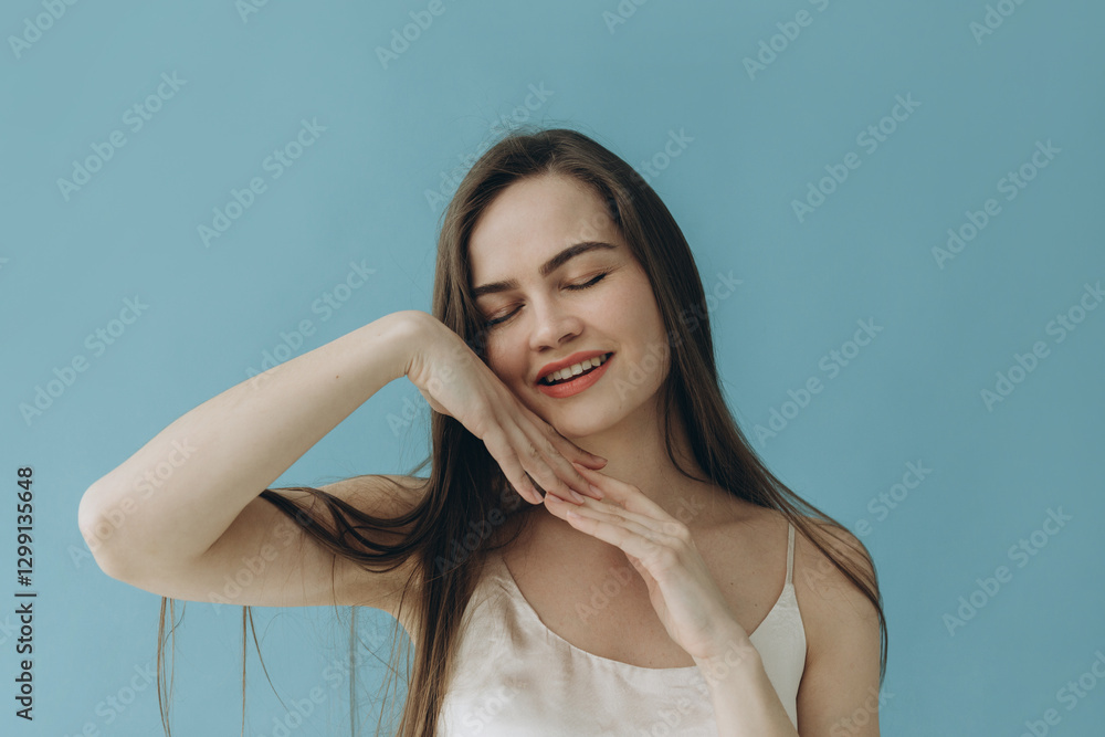 Smiling Woman Enjoying a Calm Moment Against a Blue Background Smiling Woman Enjoying a Calm Moment Against a Blue Background