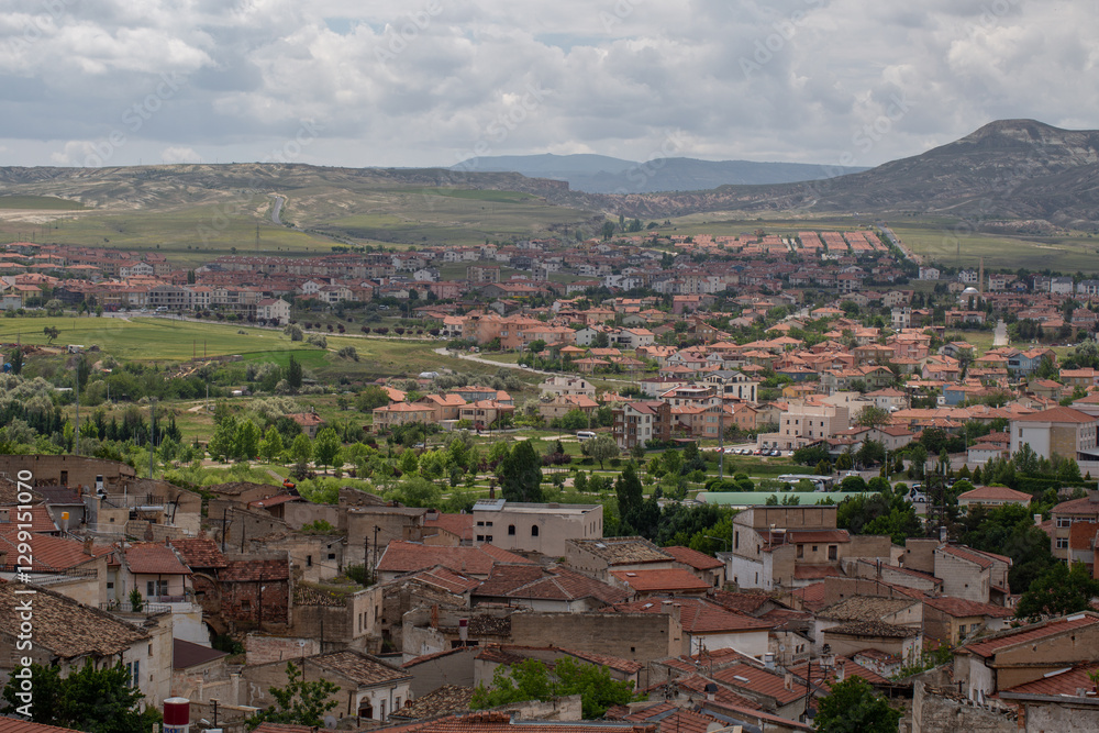 A scenic town with red-roofed houses nestled among green fields and rolling hills. Winding roads and modern buildings blend with nature, creating a peaceful yet vibrant countryside atmosphere. A scenic town with red-roofed houses nestled among green fields and rolling hills. Winding roads and modern buildings blend with nature, creating a peaceful yet vibrant countryside atmosphere.