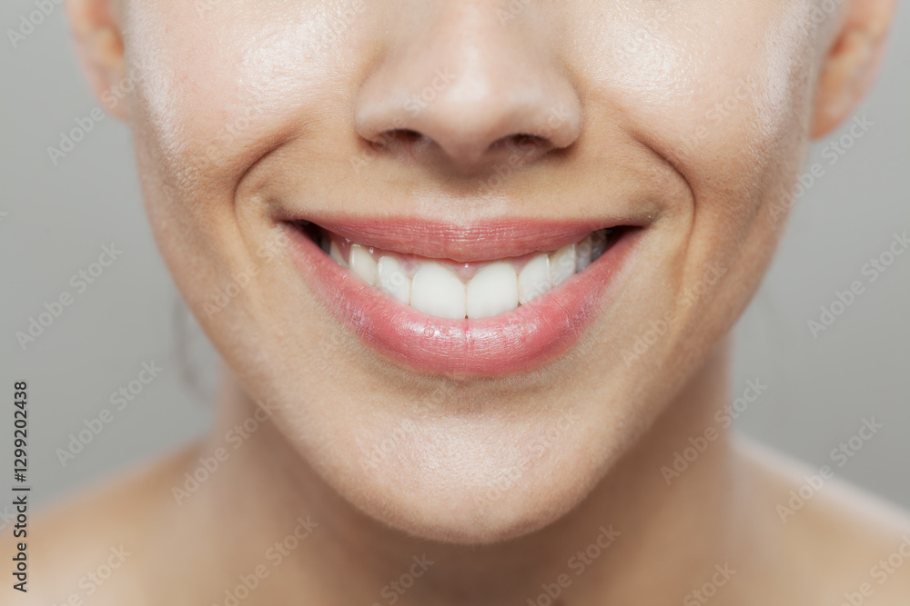 Obraz premium Close-up of a smiling woman showing healthy teeth and lips