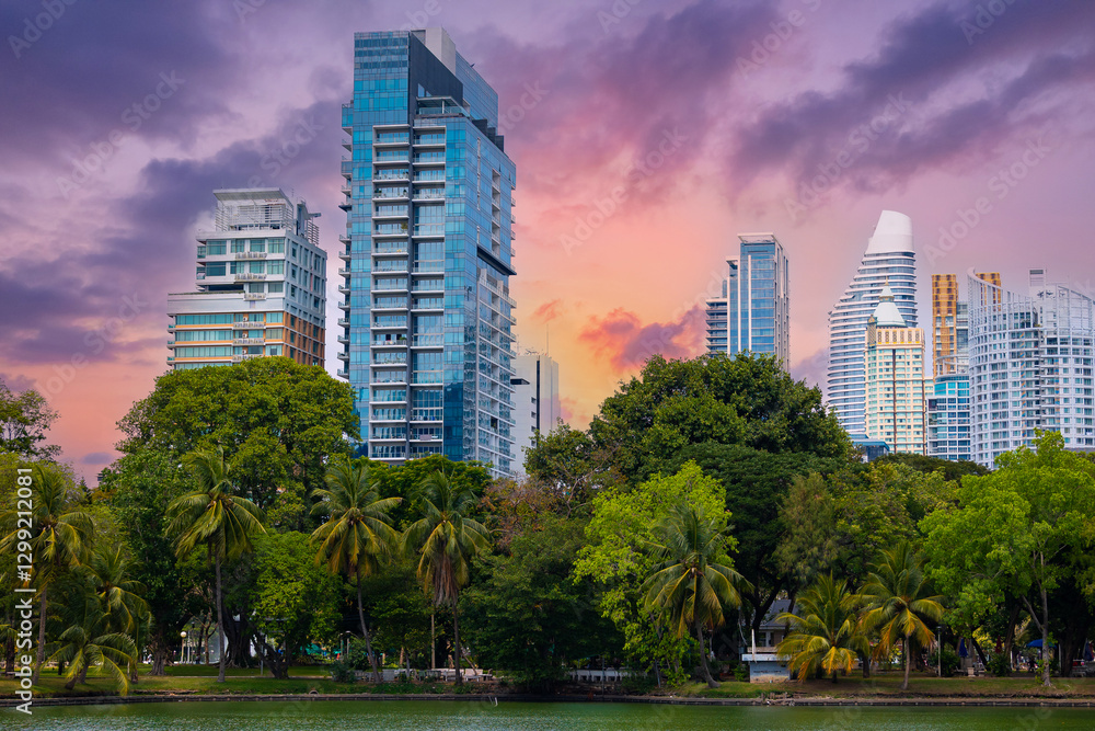 Obraz premium Lumpini Park Bangkok skyline at sunset: urban high-rise buildings and lush park landscape