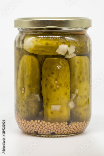 Pickles in a Glass Jar on White Background and onion pieces photo