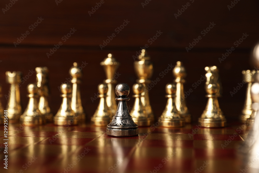Silver pawn in front of other chess pieces on chessboard. Competition concept Silver pawn in front of other chess pieces on chessboard. Competition concept