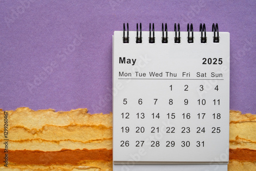 May 2025 - small spiral desktop calendar, time and business concept