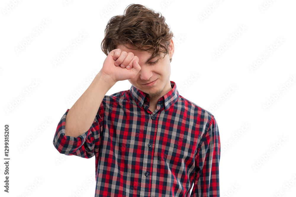 A young man in a checkered shirt wiping his forehead with a smile against a white background. A young man in a checkered shirt wiping his forehead with a smile against a white background.