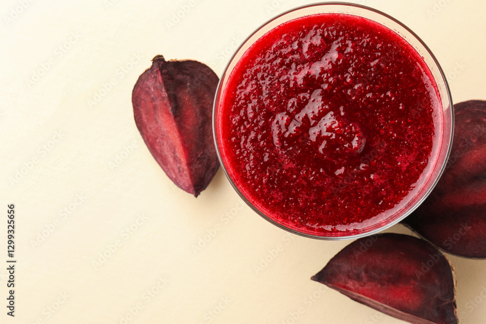 Fototapeta premium Fresh beetroot smoothie in glass and cut vegetable on beige background, flat lay. Space for text