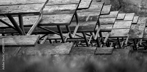 Black and white photo of park picnic tables stacked for winter storage.