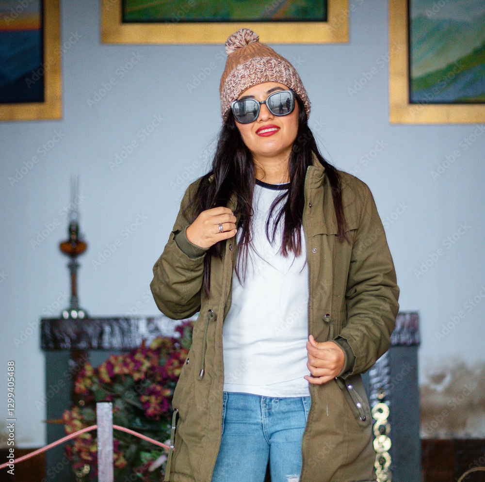 Joven aventurera abrigada con lentes disfrutando el frío en un entorno antiguo.Turista con chaqueta y gorra explorando la historia y la cultura quechua. Joven aventurera abrigada con lentes disfrutando el frío en un entorno antiguo.Turista con chaqueta y gorra explorando la historia y la cultura quechua.