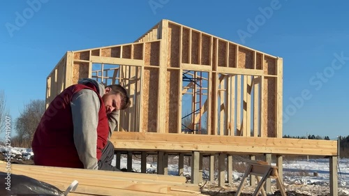 Sad angry man having problems with construction of her wooden house
