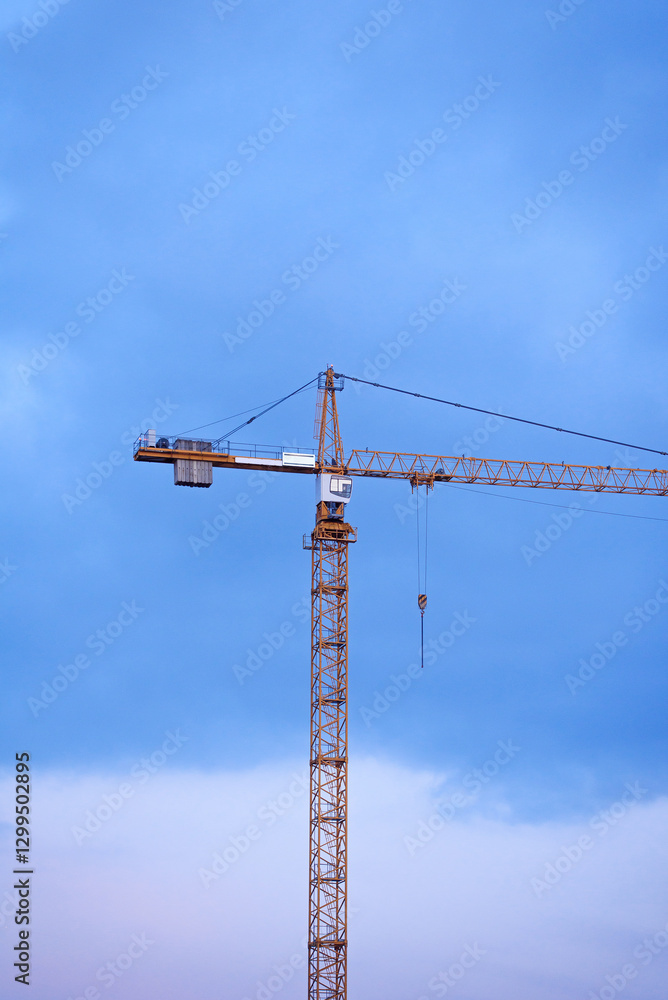 Construction cranes on the background of the sky at sunset. Construction of new residential complex. Construction cranes on the background of the sky at sunset. Construction of new residential complex.