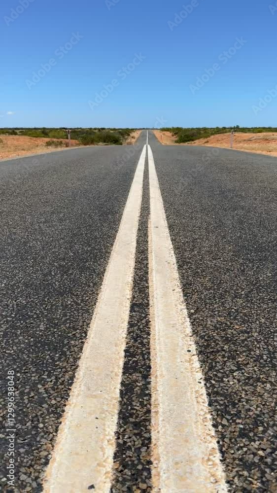 Desert Road in the middle of nowhere Western Australia under clear blue sky and red earth around it Desert Road in the middle of nowhere Western Australia under clear blue sky and red earth around it