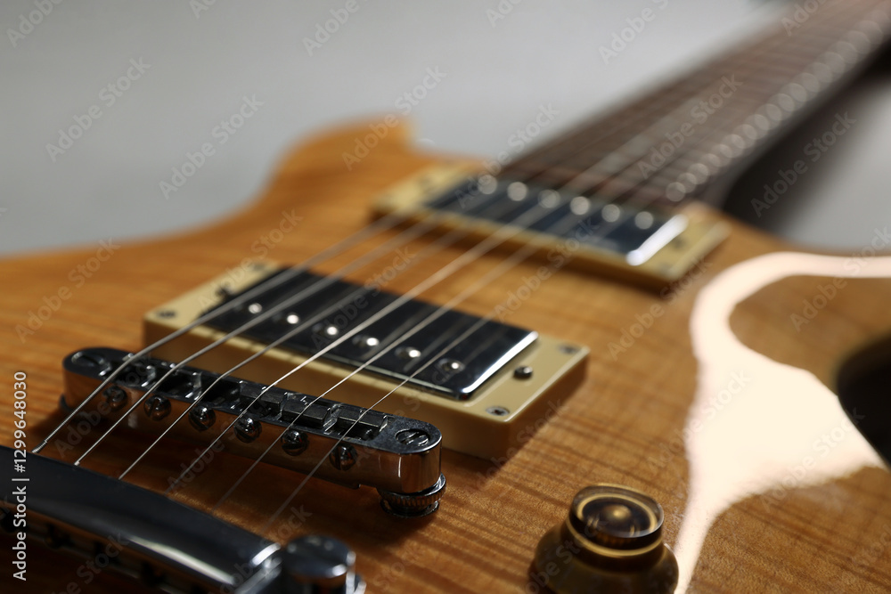 Fototapeta premium Modern electric guitar on grey background, closeup