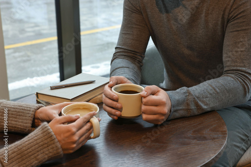 Colleagues having coffee break at wooden table in cafe, closeup