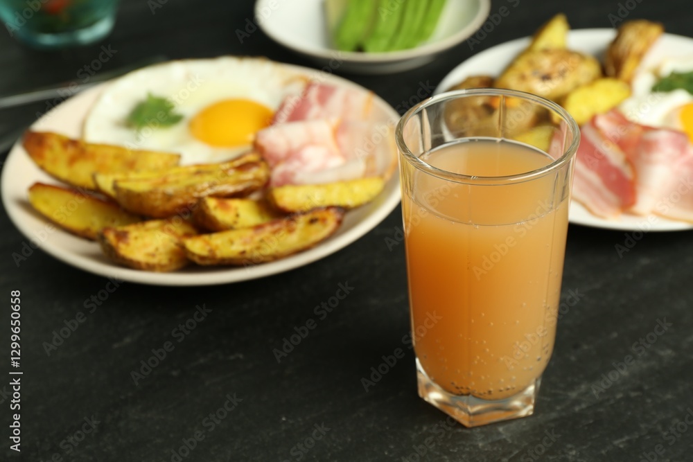 Tasty brunch. Refreshing drink, fried egg, potato and bacon on dark textured table, closeup Tasty brunch. Refreshing drink, fried egg, potato and bacon on dark textured table, closeup