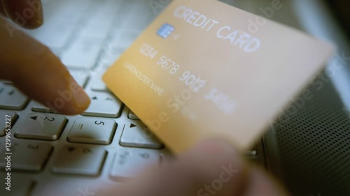 Entering credit card details on a laptop keyboard for online payment, financial transaction, cybersecurity risks, digital banking security, fraud prevention