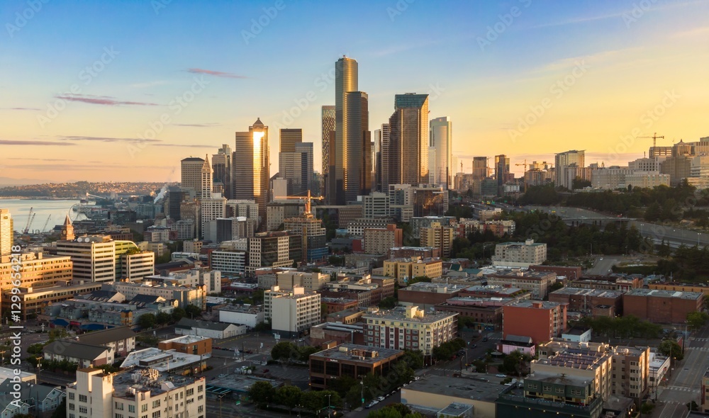 Seattle skyline at dawn, showcasing the city's diverse architecture and vibrant urban landscape. Golden light highlights the skyscrapers. Downtown, Seattle, Washington, USA Seattle skyline at dawn, showcasing the city's diverse architecture and vibrant urban landscape. Golden light highlights the skyscrapers. Downtown, Seattle, Washington, USA
