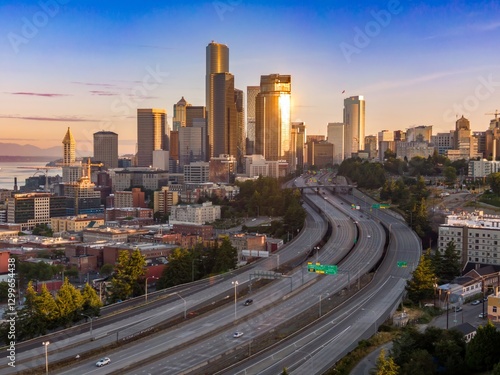 Seattle skyline at sunrise, highway traffic below. City commuters travel through the urban landscape. Downtown, Seattle, Washington, USA