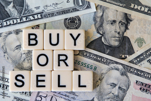 Buy or sell signage with a background of American dollars.
