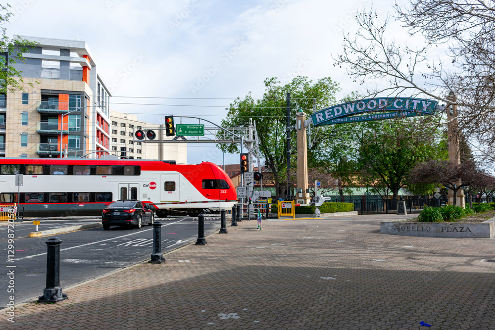 Fototapeta premium Redwood City arch with slogan Climate Best By Government Test. Caltrain electric train crosses Broadway and Arguello Street - Redwood City, California, USA - February 23, 2025