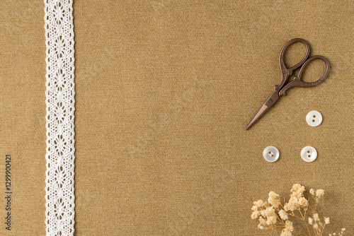 Vintage ribbon, buttons and scissors on fabric background. Flat lay, top view. Copy space